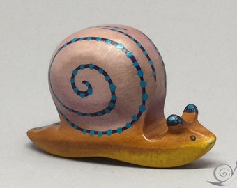 Caracol de juguete de madera de color marrón, rosa, azul con puntos. Tamaño: 8,0x 4,5 x 2,5 cm (ancho x alto x alto) aprox.