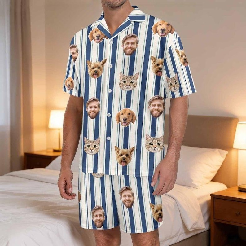 May include: A short-sleeve button-down shirt and matching shorts set featuring a vertical blue and white striped pattern. The fabric is decorated with a repeating print of various dog faces, cat faces, and a man's face scattered across the garment.
