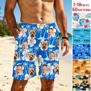May include: Blue swim trunks featuring a repeating pattern of white hibiscus flowers, palm trees, and custom faces of children and dogs. The fabric displays a vibrant tropical theme with various facial expressions integrated into the floral design.