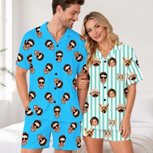 May include: A bright blue short-sleeve button-down shirt and shorts set featuring a repeating pattern of a man's face wearing sunglasses, alongside a white and teal striped short-sleeve button-down shirt and shorts set with pet faces.