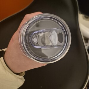 Puede incluir: Una tapa de vaso de pl&aacute;stico transparente con cierre deslizante y una peque&ntilde;a abertura para beber. La tapa es circular y parece estar hecha de pl&aacute;stico duradero. La tapa del vaso est&aacute; dise&ntilde;ada para una taza de viaje o similar.
