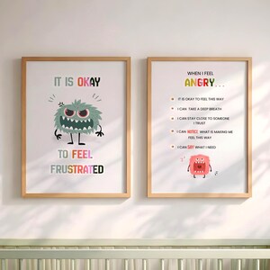 May include: Two framed wall art prints with light wood frames. The left print features a grey monster and the text IT IS OKAY TO FEEL FRUSTRATED. The right print features a pink monster and the text WHEN I FEEL ANGRY with a list of coping strategies.