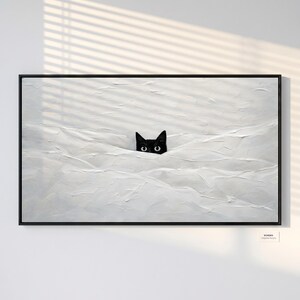 Può includere: Opera d'arte incorniciata con gli occhi di un gatto nero che spuntano da una superficie bianca strutturata. Gli occhi del gatto sono il punto focale sullo sfondo bianco. L'opera è in una cornice nera, creando un'estetica minimalista.
