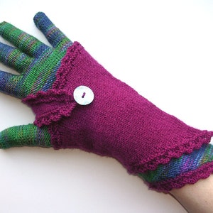 May include: A pair of knitted gloves with a purple cuff and a green and blue patterned hand. The cuff has a decorative crocheted edge and a single button.