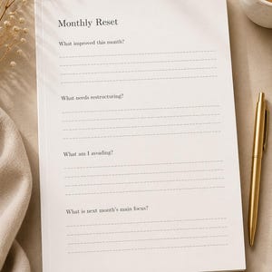 Puede incluir: Un bloc de notas de papel blanco titulado Monthly Reset con cuatro secciones que incluyen l&iacute;neas discontinuas para escribir. Las preguntas son What improved this month?, What needs restructuring?, What am I avoiding? y What is next month's main focus?
