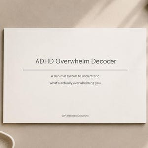 May include: A cream-colored book titled "ADHD Overwhelm Decoder" with the subtitle "A minimal system to understand what's actually overwhelming you." A pen and a cup of coffee are also visible.