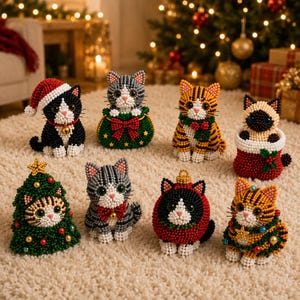Puede incluir: Ocho pequeñas figuras de gatos hechas con cuentas de colores. Los gatos presentan varios temas navideños, incluyendo un gorro de Papá Noel, un árbol de Navidad, un calcetín y coronas festivas. Cada gato tiene patrones distintos como atigrado o bicolor.