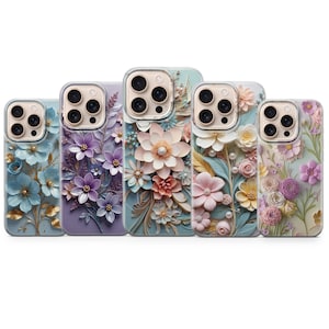 May include: A collection of five phone cases with floral designs. Each case features a different color scheme, including blue, purple, and pink, with detailed three-dimensional flower embellishments. The cases have a glossy finish and are designed for a smartphone.