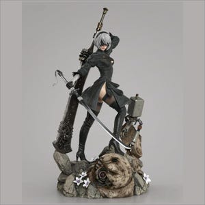 May include: A detailed figurine of a female character in a black dress and high boots, holding a large sword and a smaller blade. The figure has white hair and a blindfold. The base is a rocky terrain with small white flowers and a mechanical companion.