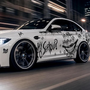 May include: A white sports car featuring black graphic decals of a wide grinning mouth, the text "WHY SO SERIOUS?", and repeated "HA" lettering. The vehicle has dark wheels and is captured in motion against a blurred city background.