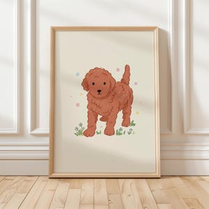 Puede incluir: Impresión enmarcada con una ilustración de dibujos animados de un cachorro de caniche marrón rojizo. El cachorro está sobre hierba verde con pequeñas flores, rodeado de estrellas de colores pastel. La obra de arte está sobre un fondo crema.