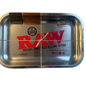 May include: A white ceramic mug with a black handle and the text "But First, Coffee" in a black, handwritten-style font. The mug is on a white surface.