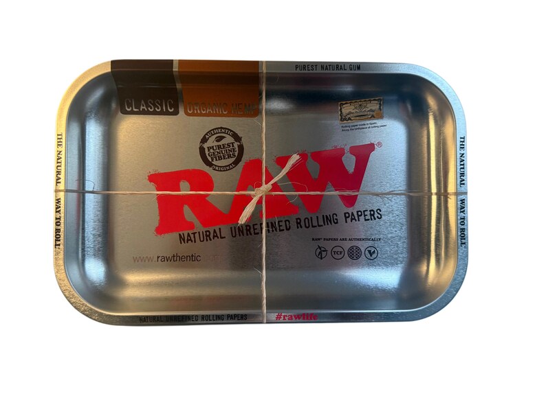 May include: A white ceramic mug with a black handle and the text "But First, Coffee" in a black, handwritten-style font. The mug is on a white surface.