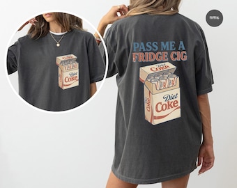 Könnte beinhalten: Ein anthrazitfarbenes Kurzarm-T-Shirt mit einem Grafikdruck auf der Rückseite und einer kleineren Version auf der linken Brust. Die Grafik zeigt einen Karton mit Diet Coke Dosen und den Schriftzug PASS ME A FRIDGE CIG in Blau und Rot.