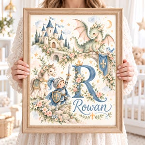 Puede incluir: Una lámina de arte enmarcada con una letra R grande en azul y el nombre Rowan en letra cursiva. La ilustración incluye un caballero con armadura sosteniendo una espada, un caballo blanco, un dragón verde, un castillo de piedra y detalles florales.