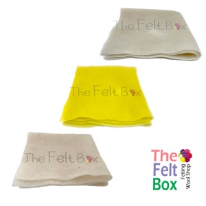 May include: Three pieces of felt fabric in white and yellow. The felt is folded and the brand name "The Felt Box" is printed on each piece.