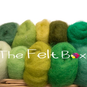 May include: A collection of 10 different shades of green wool roving in a wicker basket. The wool is arranged in a gradient from light green to dark green. The wool is soft and fluffy, and it is perfect for felting.