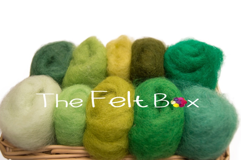 May include: A collection of 10 different shades of green wool roving in a wicker basket. The wool is arranged in a gradient from light green to dark green. The wool is soft and fluffy, and it is perfect for felting.
