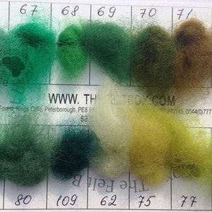 May include: A color chart with 10 different shades of green, yellow, and brown wool yarn. The chart is labeled with numbers 66 through 78 and 107. The website address WWW.THEBOX.COM is printed on the chart.