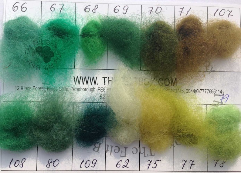 May include: A color chart with 10 different shades of green, yellow, and brown wool yarn. The chart is labeled with numbers 66 through 78 and 107. The website address WWW.THEBOX.COM is printed on the chart.