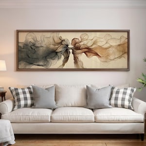 May include: A framed artwork depicts two figures in profile, their forms merging with flowing lines in shades of brown and gray. The artwork is displayed above a white sofa with gray pillows and checkered cushions.