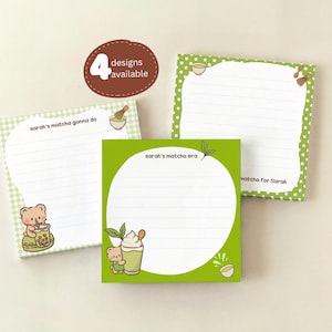 May include: Four square notepads with matcha-themed designs. The notepads feature illustrations of bears, matcha drinks, and text that reads "sarah's matcha gonna do", "sarah's matcha era", and "matcha for Sarah". The notepads have a white lined interior.