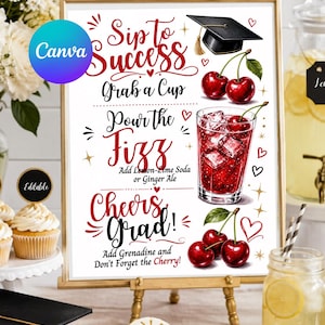May include: A framed sign for a graduation party, featuring the text "Sip to Success" and drink instructions. The sign includes a drawing of a mortarboard, cherries, and a cocktail. The sign is displayed on a small wooden easel.