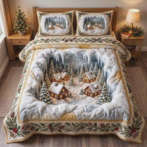 May include: A bedding set featuring a quilt and two pillow shams with a 3D-style winter village scene. The design displays snow-covered log cabins, pine trees, and icicles. The border is decorated with a pattern of green holly leaves and pinecones.