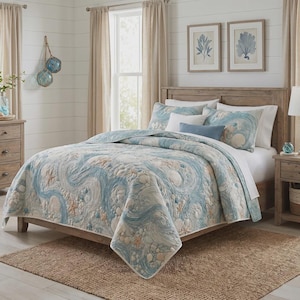 May include: A quilt set featuring a light blue and white pattern of swirling ocean waves, seashells, and starfish. The bedding includes matching pillow shams and a solid blue accent pillow, all displayed on a wooden bed frame in a bedroom.