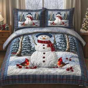 May include: A quilted bedding set featuring a snowman wearing a blue hat and red plaid scarf, surrounded by snowy birch trees and red cardinals. The design includes a blue plaid border and a repeating snowman pattern on the two matching pillow shams.