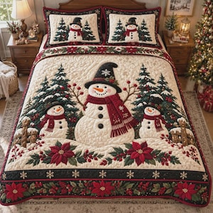 May include: A cream-coloured quilted bedspread and two matching pillow shams featuring a central large snowman wearing a black hat and red scarf, flanked by two smaller snowmen, evergreen trees, red poinsettias, and a black border with snowflakes.