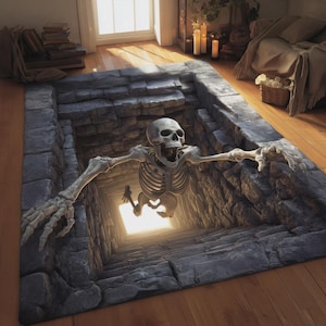 Puede incluir: Una alfombra rectangular con una ilusión 3D de un pozo de piedra. Una figura esquelética parece estar emergiendo del pozo, con los brazos extendidos. La alfombra presenta texturas de piedra gris y una luz brillante en el fondo del pozo.