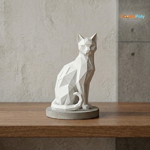 May include: A white geometric cat sculpture sitting on a gray concrete base. The cat is in a seated position with its tail curled. The sculpture has a modern, polygonal design. The cat is on a wooden surface.