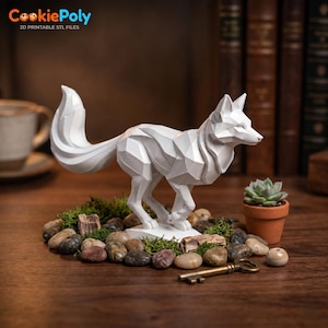 May include: A white geometric fox figurine with a faceted surface design, standing in a running pose. The fox is surrounded by small smooth river stones, green moss, a small terracotta pot with a succulent, and a metal skeleton key.