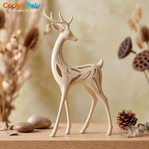 Peut inclure: Une figurine de cerf de couleur crème présentant un design ajouré complexe sur le corps, incluant des découpes en forme d'étoile. La sculpture repose sur quatre pattes fines et arbore des bois détaillés, avec une finition mate et lisse.