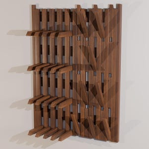 May include: A wall-mounted wooden rack featuring a series of vertical slats and multiple horizontal pegs extending outward. The structure is crafted from dark brown wood with a visible grain pattern, designed for organizing items on a flat surface.