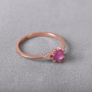 Anillo de promesa minimalista con rubí natural de 5 mm en oro rosa de 14 quilates y detalles de circonitas cúbicas.