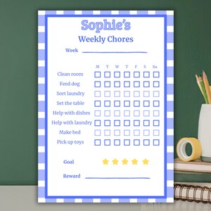 Puede incluir: Un gráfico de tareas semanales con borde de cuadros azules y blancos, titulado "Sophie's Weekly Chores". El gráfico incluye casillas de verificación para tareas diarias como limpiar una habitación, alimentar a un perro y hacer la cama.