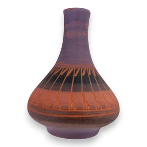 Puede incluir: Un jarrón de cerámica hecho a mano con una base bulbosa y un cuello estrecho. El jarrón presenta una paleta de colores púrpura, negro y naranja. El diseño incluye líneas verticales y patrones geométricos, agregando un toque artístico a la pieza decorativa.