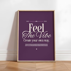 May include: A framed print with a purple background and the words "Feel The Vibe" in a decorative font. The print also includes the text "Create your own way" and other inspirational text. The frame is a light brown color.