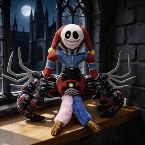 May include: A plush doll featuring a white, round face with a wide smile and one eye, wearing a red and blue jester-style outfit. It has multiple black, patterned spider-like legs, long silver-colored clawed hands, and two soft, fuzzy legs in pink and blue.