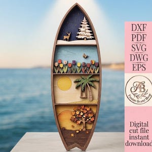 Puede incluir: Un objeto decorativo de pared de madera con forma de tabla de surf y cuatro estantes horizontales que representan escenas estacionales: un ciervo y un pino en invierno, tulipanes en primavera, una playa de verano con palmera y un árbol otoñal.
