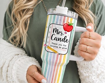 Könnte beinhalten: Ein Edelstahlbecher mit Henkel und Strohhalm, verziert mit pastellfarbenen vertikalen Streifen. Das Design zeigt ein Notizblock-Motiv mit einem roten Apfel, einem gelben Bleistift und dem Text Mrs. Cande Thank you for helping me grow.