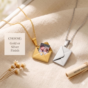 Könnte beinhalten: Zwei Halsketten mit Umschlaganhängern, eine goldfarbene und eine silberfarbene, jeweils mit einer Kette. Der goldfarbene Anhänger ist geöffnet und zeigt ein kleines Foto. Der Text auf dem Bild lautet "CHOOSE: Gold or Silver Finish".