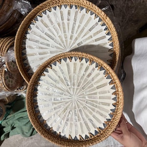 Puede incluir: Una taza de cerámica blanca con un asa negra y el texto "But First, Coffee" en negrita negra. La taza está sobre un fondo borroso. La taza mide aproximadamente 10 cm de altura.