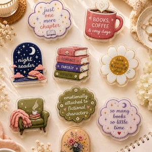 May include: A collection of nine decorative acrylic pins featuring book-themed illustrations and text including just one more chapter, books coffee & cozy days, night reader, romance fantasy mystery, book are my happy place, emotionally attached to fictional characters, so many books so little time, and a green armchair with a blanket and a vase of flowers.