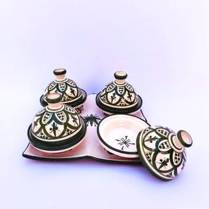 May include: A white ceramic mug with a black handle and the text "But first, coffee" in a black, handwritten-style font. The mug is on a white surface.