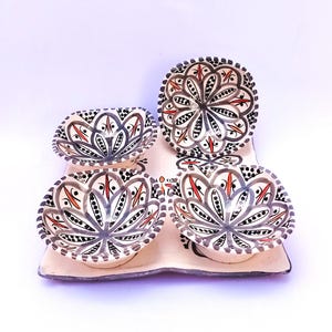 Peut inclure: Un ensemble de quatre petits bols en céramique peints à la main avec un plateau assorti. Les bols et le plateau sont décorés d'un motif floral noir, gris et rouge sur fond crème. Les bols mesurent environ 10 cm de diamètre.