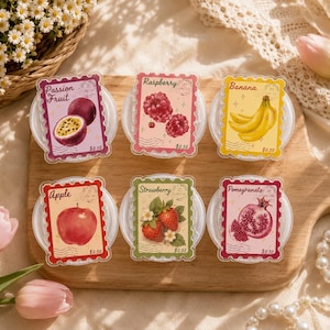 May include: Six rectangular stickers shaped like postage stamps, each featuring a different fruit illustration and name: Passion Fruit, Raspberry, Banana, Apple, Strawberry, and Pomegranate. Each sticker includes a $0.50 price mark and postmark.