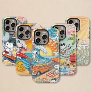以下が含まれることがあります： スヌーピーとウッドストックがビーチで遊ぶ様子を描いた5つのスマホケース。各ケースには、サーフィン、日光浴、音楽演奏などの鮮やかなイラストが描かれており、海の波と晴れた空を背景にしています。